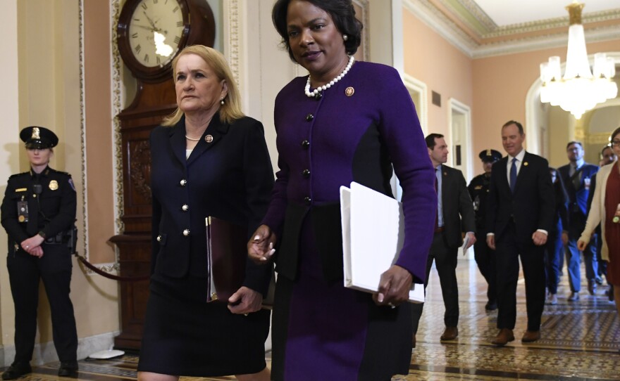 Impeachment managers Rep. Val Demings, D-Fla., center, and Rep. Sylvia Garcia, D-Texas, left, walk to the Senate trial of President Trump in February.