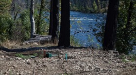 Pipes extend through the soil near a river. 