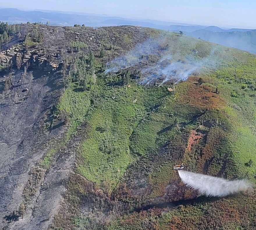 A Chinook helicopter drops water on the Perins Peak Fire near Durango, CO