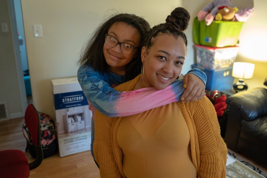 Lauryn Foster hugs her mom, Alesia, in a two-bedroom apartment they share with her grandmother in Maplewood so she can attend MRH schools. Alesia is hoping to move out next year but may not be able to afford an apartment in the district.