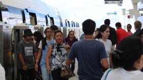 Passengers get on and off a Skyline train car at the new station serving Kalihi and the Middle Street Transit Center, on the opening day of the rail's second segment, Oct. 16, 2025.