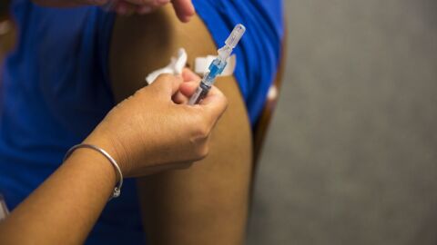 Person getting a vaccine in their left arm