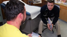 Dr. Dan Shuman (right), who was recruited to the Ashland Health Clinic as part of its mission-focused medicine program, consults with a patient about smoking cessation. 