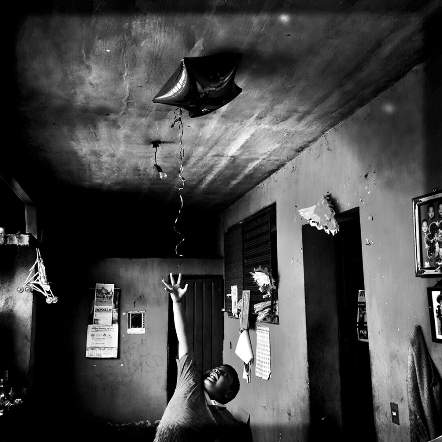 Angel, 8, tries to grab the star balloon his aunt had just brought home from work. Angel's dad is one of the 43 students missing in Mexico.