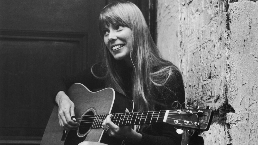 Joni Mitchell strums her guitar outside The Revolution club in London in 1968.