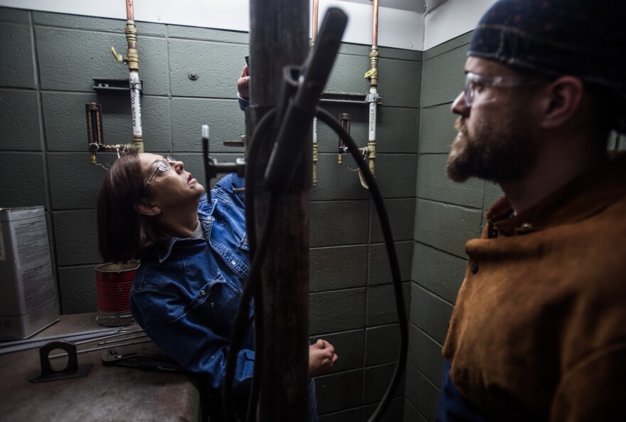 Spartanburg Community College welding instructor Teresa Elder (left) grades Harris during class.