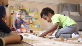 A child plays with a train set at Bumble Art Studio day care center in Astoria, Ore., Friday, Sept. 2, 2022. (Craig Mitchelldyer/AP)