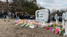 Community members bring bouquets of flowers to the Michigan State University rock to remember Alexandria Verner, Arielle Anderson, and Brian Fraser, the three students who were killed in the mass shooting Monday.