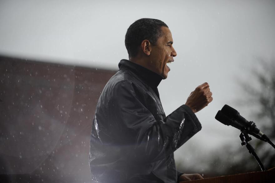 Then-Senator Barack Obama speaks as rain falls during a rally at Widener University in Chester, Penn. in October 2008.