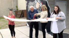 Marce King (right) and Mike Spinks (left) cut the celebratory "ribbon" – a roll of toilet paper – at the public restroom unveiling Monday.