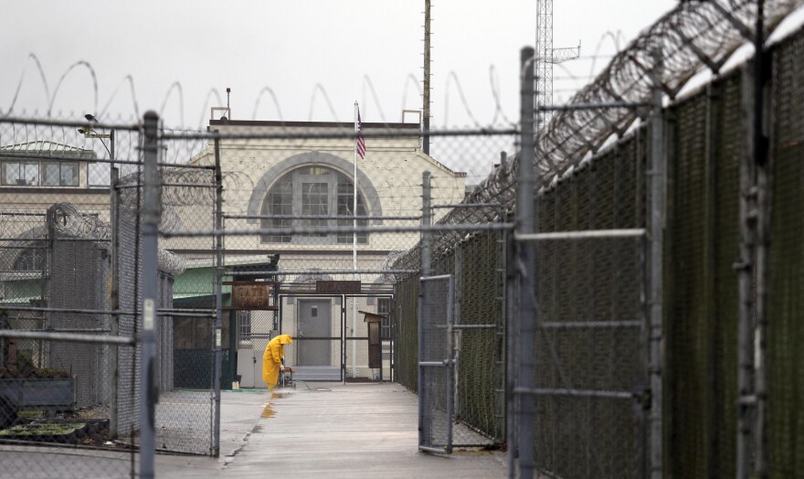 A man does maintenance work between razor wire-topped fences at the Monroe Correctional Complex in Monroe in January 2016.