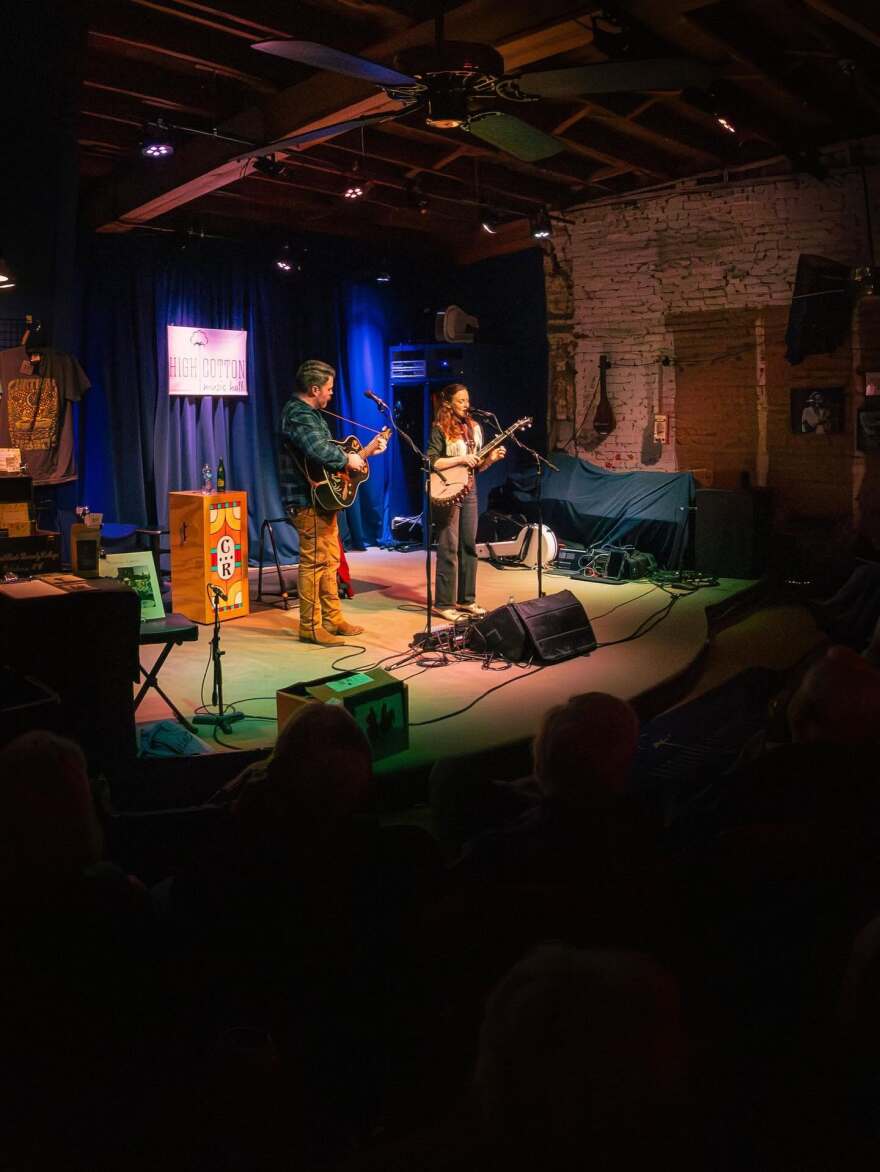Two musicians perform onstage.