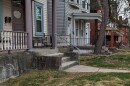  A row of two story wood-frame houses in Mt. Auburn with a few steps leading up to the porch.