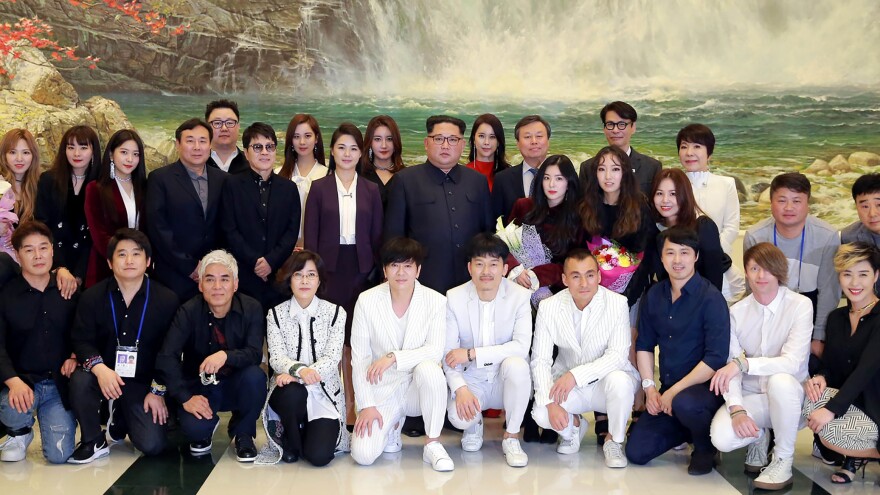 A picture provided by North Korea's official Korean Central News Agency shows North Korean leader Kim Jong Un (back, center) and his wife Ri Sol-Ju (second row, sixth from left) posing with South Korean musicians after their performance in the East Pyongyang Grand Theater in Pyongyang.