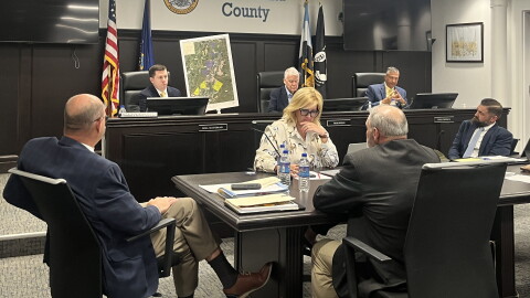 Lackawanna County Commissioner Bill Gaughan, left, holds up a map he had the county's land development office create of two proposed massive power plants for the county.