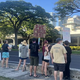 A protester in Honolulu holds a sign reading, "Due process for all," on Jan. 25, 2026.