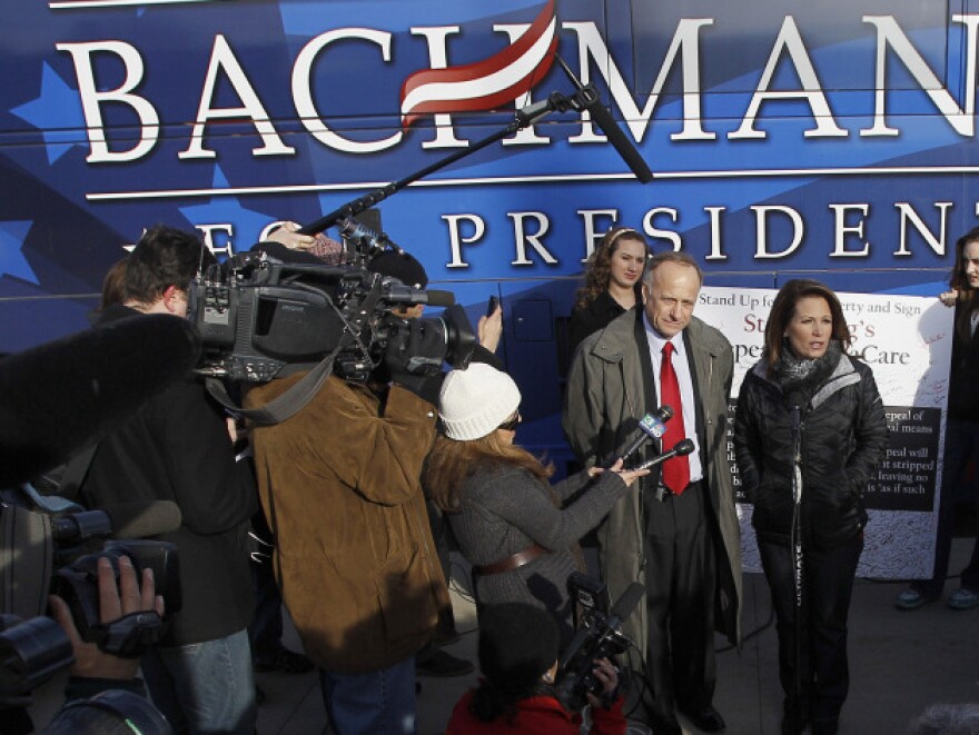 Republican presidential candidate Michele Bachmann (center) talks to the media after a campaign stop Tuesday at Valley High School in West Des Moines, Iowa.