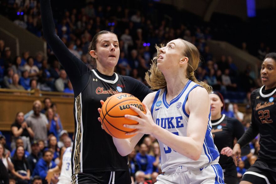 Duke's Toby Fornier, right, handles the ball as Charleston's Sophia Tougas, left, defends during the first half in the first round of the NCAA college basketball tournament, Friday, March 20, 2026, Durham, N.C. (AP Photo/Ben McKeown)