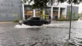 A car drives through floodwater on Colonial Avenue in Norfolk on Tuesday, Aug. 4, 2026.