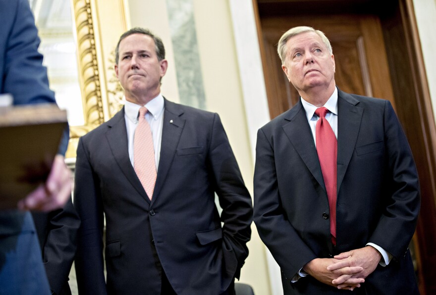 Sen. Lindsey Graham, R-S.C. (right), and Rick Santorum, former senator from Pennsylvania, listen during a health reform news conference on Capitol Hill last week.