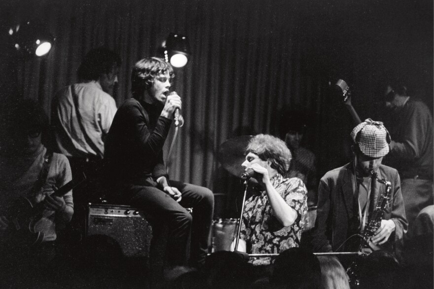 Jim Morrison, seated on an amplifier, sits in with the band Them at the Whisky a Go Go in 1966. Van Morrison (no relation) is at the keyboard.