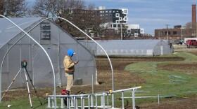 An Ohio City Farm employee works to install a new cart system to assist with transporting harvested produce to the new Roundstone Pavilion's wash and packing station.