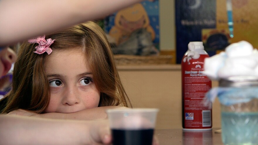 Preschool student Stormy Frazier watches an experiment unfold in Nikki Jones' classroom.