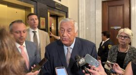 Mass. House Speaker Ron Mariano speaks to reporters at a scrum at the State House on July 30, 2026. House Ways and Means Chair Aaron Michlewitz is pictured on the left. Rep. Dan Cahill stands behind Mariano on the left, as does Rep. Alice Peisch on the right.