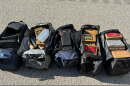 Several duffel bags of cocaine laid out on the road.