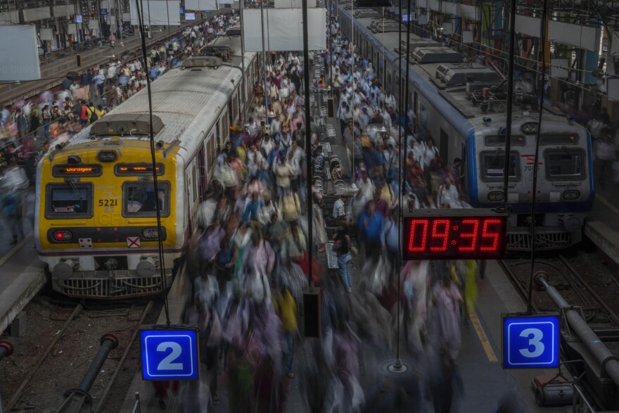 Indian commuters get off trains at the Church Gate railway station in Mumbai, India, Monday, Nov. 14, 2022.