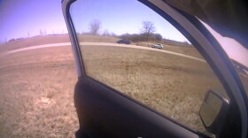 This screengrab was taken from a State Police officer's body-worn camera, showing two vehicles pulled onto the shoulder of northbound Interstate 55 near Lexington. The man who was shot and killed by police is visible between the blue car and light-colored SUV in frame.