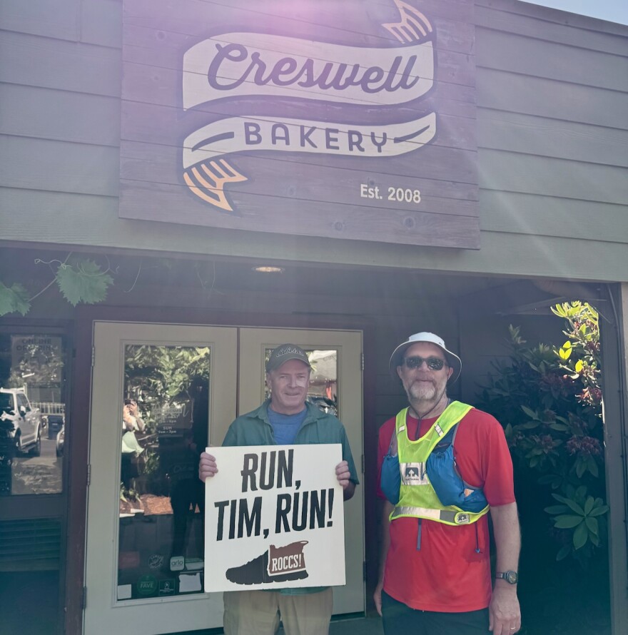 Two men stand in front of a bakery.