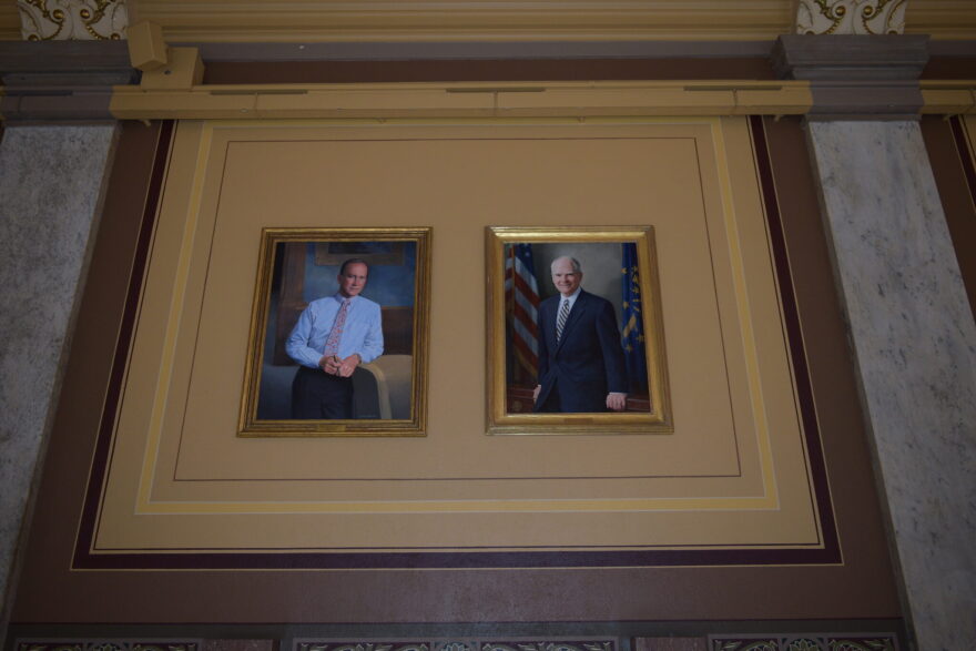 Portraits of former Govs. Mitch Daniels, left, and Joe Kernan hang side by side at the Indiana Statehouse as part of a new display intended to make the paintings more accessible to visitors.