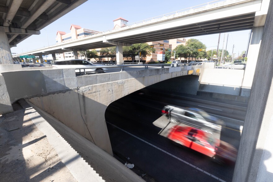 The bridge over I-35 at 32nd Street. Cars on the mainlanes are going by. Saint David's Medical Center can be seen in the background.