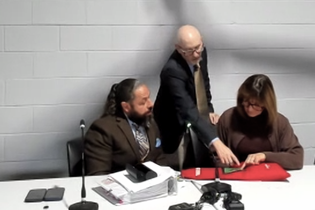 Members of the Wayne County Board of Canvassers consult with an elections official while overseeing the tabulation of 37 additional ballots from Hamtramck's 2025 municipal elections.