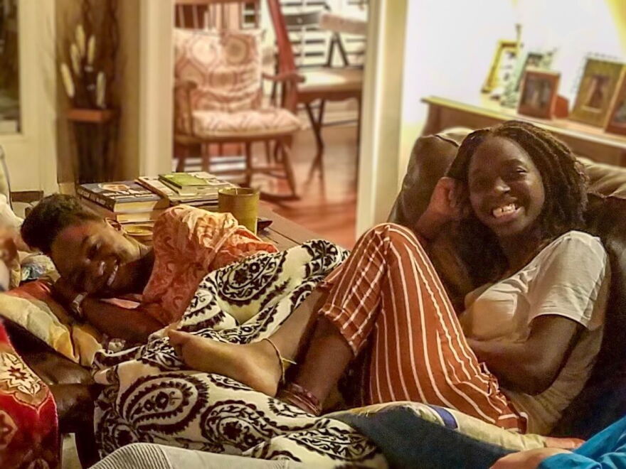 Wotts Mercy, 26, and her 17-year-old sister, Sarah Fertil (right) cozy up on a couch during Thanksgiving.  
