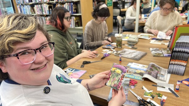 After cutting and gluing recycled materials, Britiny Vetitoe shows off her finished junk journal. It's a small, analog break from the digital world.