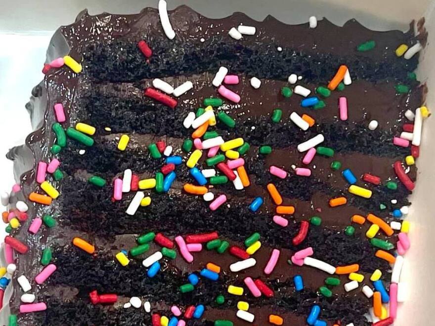 A slice of the 12-layer chocolate cake known as "Bruce" is adorned with colorful sprinkles at the British bakery Get Baked. But regulators say the topping is illegal, as it includes a color additive that is permitted only for other uses.