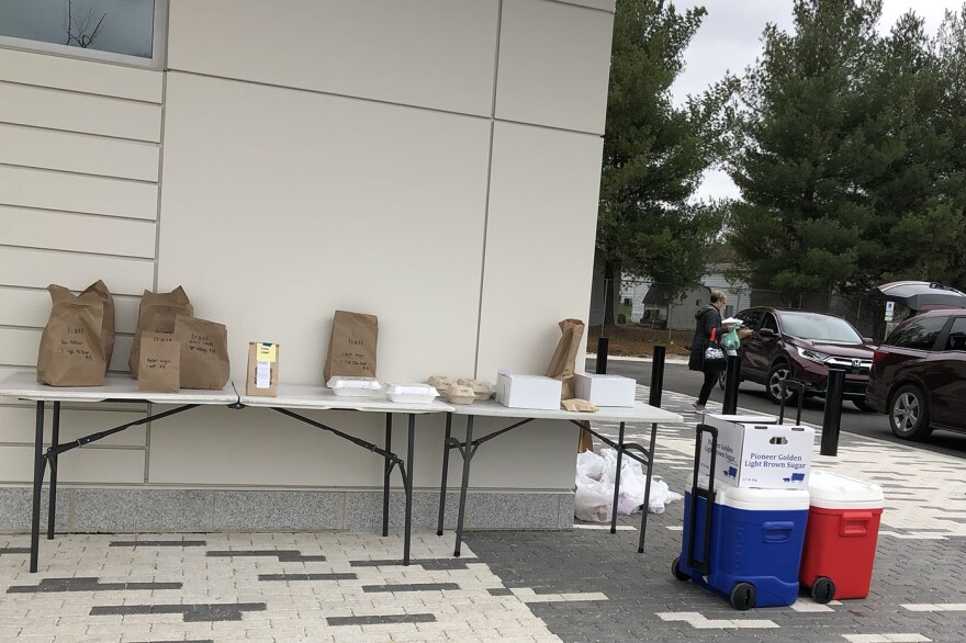 Runners at the Bloomington Winter Farmers Market grabbed orders from various vendors and delivered them to customer's cars on Saturday March 21, 2020 at the Switchyard Pavillion.