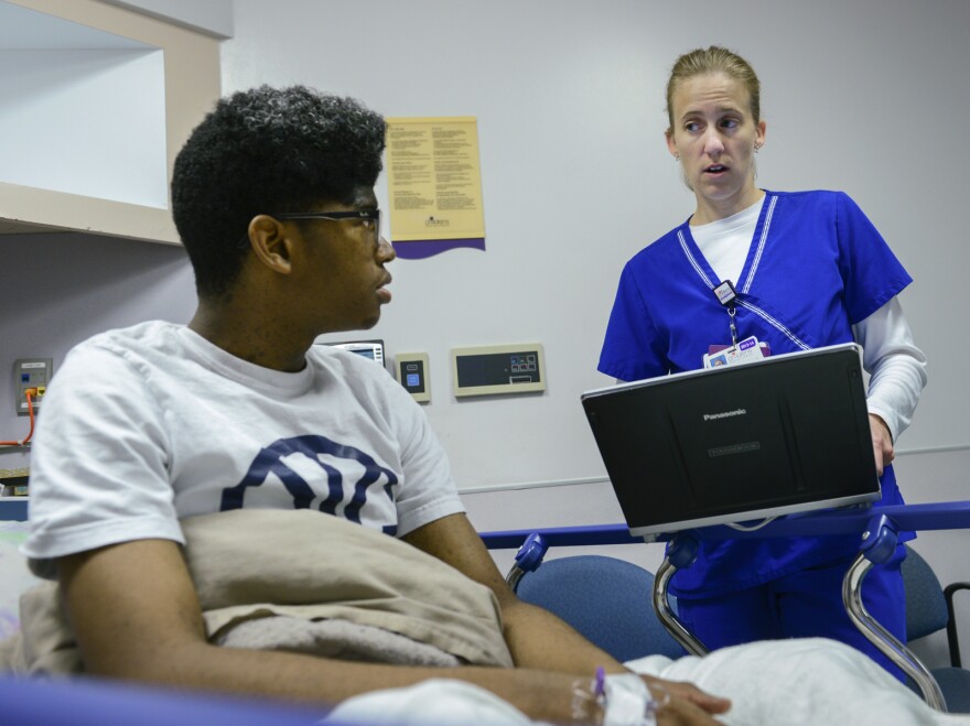 Julian Coleman, 16, tells emergency department pharmacist Jamie Tweedle about his medication history.