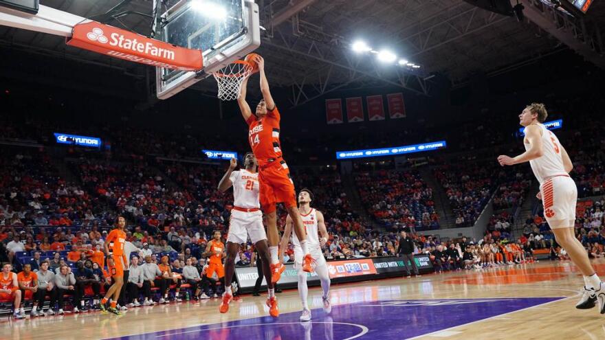 Jesse Edwards (orange, 14) dunks against Clemson on Wednesday.