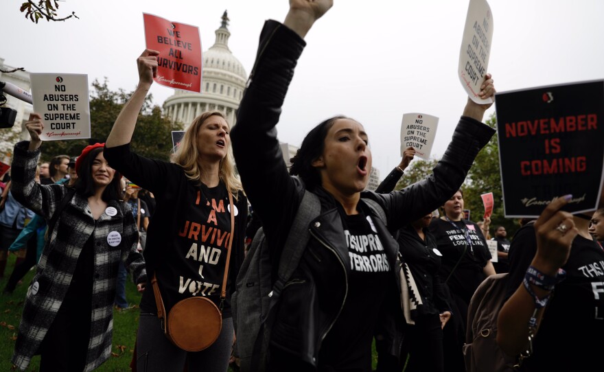 Demonstrators march in front of the Capitol.