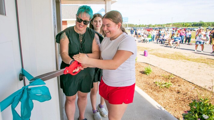 From left, Jaclyn Dugan and her daughters Adelyn Roof, 12, and Abby Roof, 16, cut the ribbon on their new home as Habitat for Humanity Grand Traverse Region celebrated the final two homes in its New Waves Community with a home dedication ceremony on Wednesday at the neighborhood near the intersection of Bugai and M-72 in Elmwood Township. The project, a partnership with New Waves Church of Christ, dedicated the first two homes on the 13 home project in 2024 on a 20 acre parcel. Each has 3 bedrooms, one and a half baths and a garage.