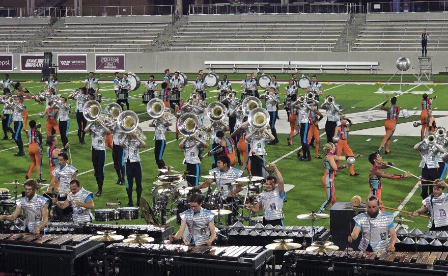 A variety of drum and bugle corps performing on a football field