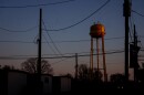 Crows fly past the Murphysboro, Illinois water tower during sunrise on Tuesday, March 19, 2024.