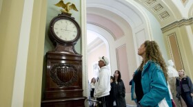 <strong>Still Right Twice A Day:</strong> Visitors look at the Ohio Clock outside the Senate chamber on Capitol Hill Sunday. The clock that has stood watch over the Senate for 196 years stopped running shortly after noon Wednesday. Employees who wind the clock weekly were furloughed in the federal shutdown.