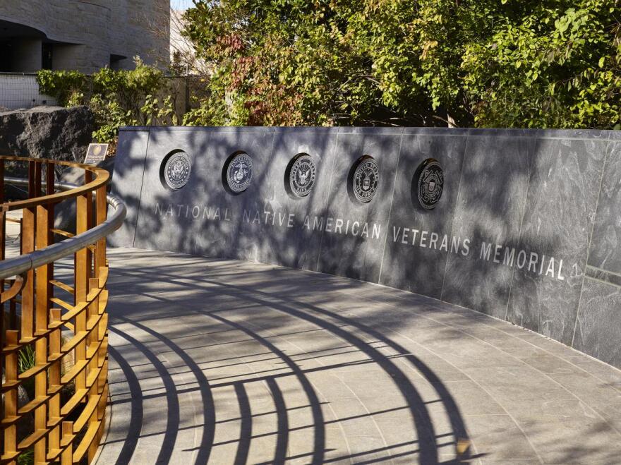 The Native American Veterans Memorial is located in a wooded area near the National Museum of the American Indian in Washington, D.C. Visitors access it from a meandering pathway.