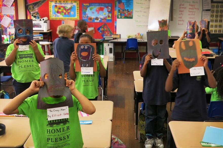 Second-graders in Chantell Nabonne's class hold up their masks, part of a class project on New Orleans's culture and art.