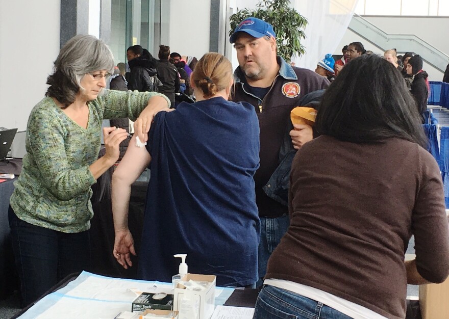 A woman receives a flu shot at a clinic. 