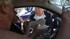 President Donald Trump and North Carolina Gov. Roy Cooper, left, hand out food at Temple Baptist Church, where food and other supplies are being distributed during Hurricane Florence recovery efforts, Wednesday, Sept. 19, 2018, in New Bern